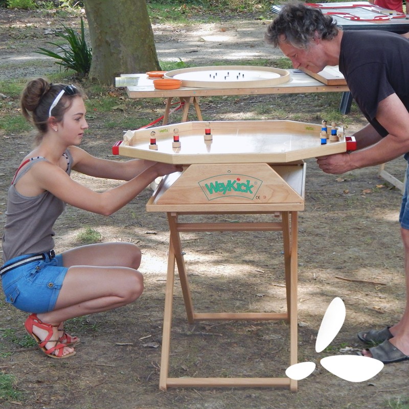 Un père et sa fille jouent a un jeu géant en bois à une animation grand public